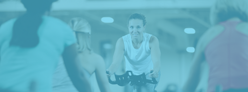 woman teaching group indoor cycling class